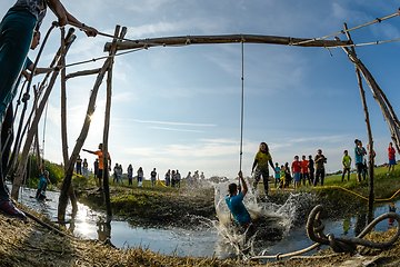 Image showing Athletes go through mud and water