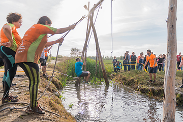 Image showing Athletes go through mud and water