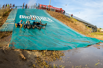 Image showing Athletes sliding to mud and water