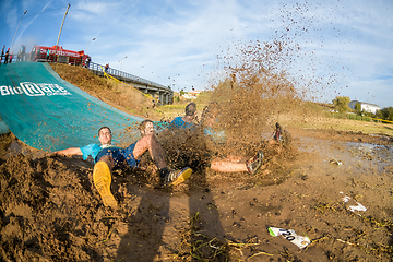 Image showing Athletes sliding to mud and water