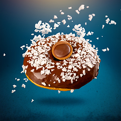 Image showing Chocolate donut with coconut flackes flying i