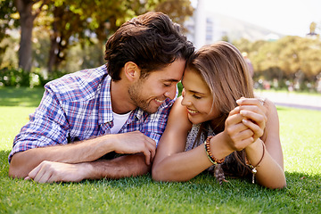 Image showing Couple, love or forehead touch on grass date, nature park or garden bonding on valentines day, romance or anniversary trust. Smile, happy woman or man lying in relax environment or partnership picnic