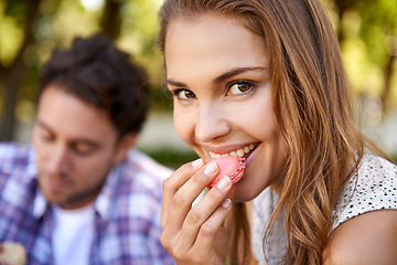 Image showing Couple picnic, woman eating candy and portrait on grass with happiness, kindness and love on valentines date. Girl, macaroon and man together at nature park with food for bonding, romance and care