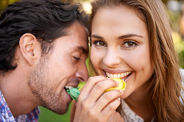 Image showing Man, woman and picnic portrait with candy feeding on lawn with happiness, kindness or valentines day love. Happy couple, macaroon or together at nature park with sweets for bonding, romance or care