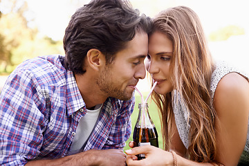 Image showing Young couple drinking soda together in park, summer holiday or valentines date for outdoor romance and love. Relax, happy people or woman with partner sharing a cola bottle and straw in garden picnic