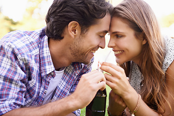 Image showing Nature, happy and couple sharing a drink with love on a summer picnic date in an outdoor garden. Happiness, smile and young man and woman drinking a bottle of cola together relaxing on grass in field