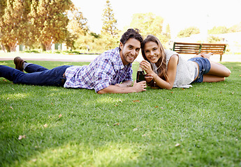 Image showing Happy couple, park and valentines day date portrait with a drink on grass for love, bonding and time together. Smile of a young man and woman in nature for a summer picnic with a cola bottle outdoor