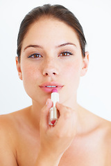 Image showing Woman, face and lipstick for makeup, cosmetics or skincare isolated against a white studio background. Portrait of beautiful happy female applying cosmetic product on lips for beauty or self love