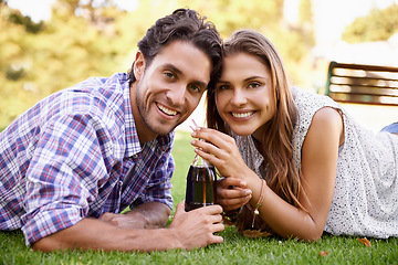 Image showing Happy couple drink soda together in park, summer holiday or valentines date in a portrait for outdoor fun. Relax, love and young people or woman with partner sharing a cola bottle in garden picnic