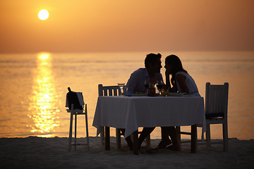 Image showing Love, ocean sunset and couple at table for romantic valentines day date at the beach in Bali in silhouette. Romance, food and wine on vacation for man and woman in loving relationship in Indonesia