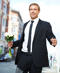 Image showing Man, gift and valentines day flowers or roses on a city street for a date, love and motivation. Model person in a formal suit with a flower bouquet to celebrate holiday or event with urban travel