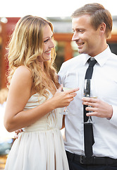 Image showing Love, wine and couple at a party, smile and happy while talking, flirting and bonding at outdoor event. Champagne, romance and man with woman in romantic moment, cheerful on first date or anniversary