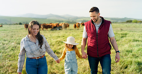 Image showing Farm, family and cattle with a girl, mother and father walking on a field for agriculture or sustainability farming. Farmer, love and parents with a daughter on a grass meadow with cows on a ranch