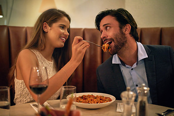 Image showing Love, restaurant date and woman feeding man spaghetti on valentines day, happy and romantic dinner. Romance, valentine and food with wine, couple celebrate marriage or relationship with time together