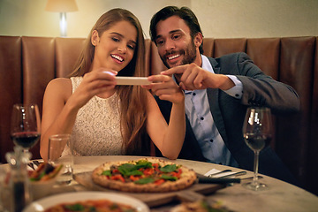 Image showing Restaurant, couple and phone for photo of food, pizza or romantic date night meal for valentines day. Social media, picture and influencer man with woman on smartphone for blog, review or eating post