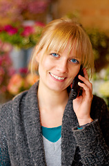 Image showing Portrait, woman and phone call for communication, connection and flowers with girl, smile and talking. Face, Canadian female or lady with smartphone, conversation or happiness with beautiful bouquets