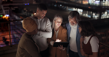 Image showing Tablet, collaboration and night with a business team working together in the city on their office balcony. Finance, teamwork and meeting with a man and woman employee group talking strategy outside