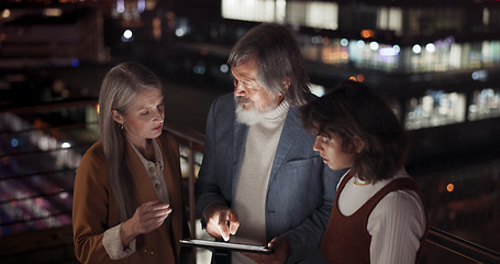 Image showing Tablet, collaboration and night with a business team working together in the city on their office balcony. Finance, teamwork and meeting with a man and woman employee group talking strategy outside