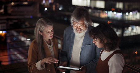 Image showing Tablet, collaboration and night with a business team working together in the city on their office balcony. Finance, teamwork and meeting with a man and woman employee group talking strategy outside