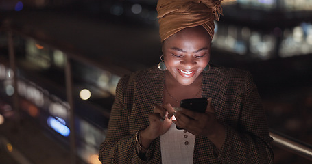 Image showing City, rooftop and black woman on a phone at night networking on social media or the internet. Technology, happiness and African lady browsing online with a cellphone on an outdoor balcony in a town.