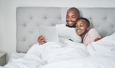 Image showing Tablet, bedroom and a black couple streaming an online subscription service while in their bed together to relax. Social media, entertainment or video with a man and woman relaxing in the morning