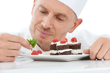 Image showing Dessert, plate and chef in a studio cooking with mint for a sweet treat, snack or craving. Culinary, food industry and man baker baking a delicious cake with fruit while isolated by white background.