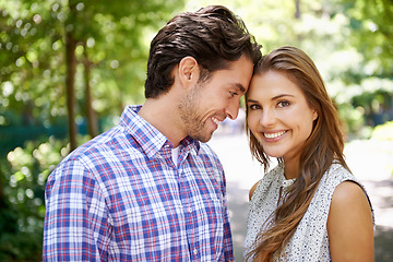 Image showing Portrait, couple and hug in park with forehead, touch and bonding against a blurred background. Face, embrace and man with woman in nature, smile and excited for reunion, relationship or togetherness