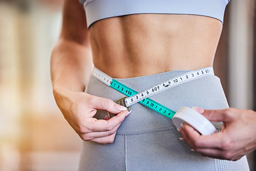 Image showing Tape measure, stomach and woman at gym for weight loss, diet or exercise on blurred background. Fitness, measuring and girl on flat belly from training, workout or healthy lifestyle results on mockup