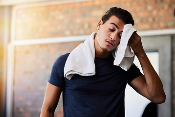 Image showing Tired, sweat and man at gym for exercise, cardio or intense workout on brick wall background. Exhausted, athlete or male with towel stop to rest or recover from sport, performance or challenge