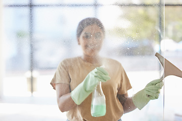 Image showing Happy, woman and cleaning window with smile, spray bottle and soap or detergent housekeeping in home or hotel. Housework, smudge and housekeeper or cleaner service washing dirt off glass in apartment