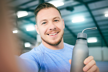 Image showing Fitness, selfie and portrait of man with water bottle at gym for training, exercise and cardio on blurred background. Face, athletic and guy smile for photo while relax with drink during body workout