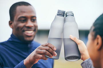 Image showing Fitness, water bottle and black couple toast outdoors together after workout, exercise or training. Sports targets, celebration and man and woman cheers with liquid for hydration to celebrate goals.