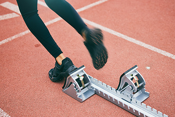 Image showing Feet, running and race start blocks with woman athlete on stadium, motion blur and speed, action and fitness outdoor. Training, runner sneakers and sports training with exercise and cardio on track