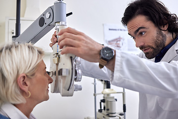 Image showing Senior woman in a vision test or eye exam for eyesight by doctor, optometrist or ophthalmologist with medical aid. Mature patient in optical exam to see or check glaucoma with a helpful optician