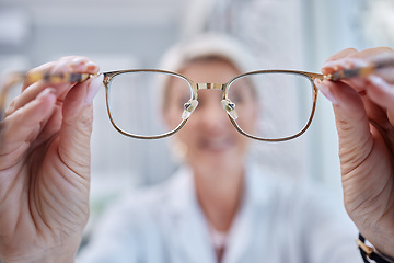 Image showing Glasses, vision and optometrist doctor hands for eye wellness and health test in a shop or hospital. Healthcare, consulting and medical employee holding a frame with tested lens for customer