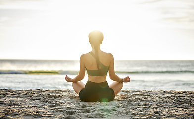 Image showing Woman, yoga and meditation on the beach sunset for spiritual wellness, zen or workout in the outdoors. Female yogi relaxing and meditating for calm, peaceful mind or awareness by the ocean coast