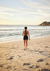 Image showing Woman, beach and walking on sand for travel, vacation or holiday in nature for summer. Fitness person at ocean for sea or water view for peace, relax and calm time for freedom and mental health