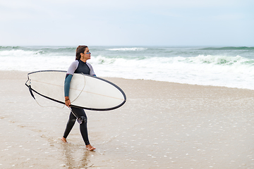 Image showing Young female surfer wearing wetsuit