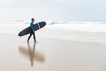 Image showing Young male surfer wearing wetsuit