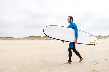 Image showing Young male surfer wearing wetsuit