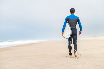 Image showing Young male surfer wearing wetsuit