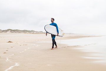 Image showing Young male surfer wearing wetsuit