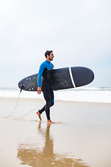 Image showing Young male surfer wearing wetsuit