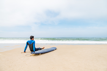 Image showing Young male surfer wearing wetsuit