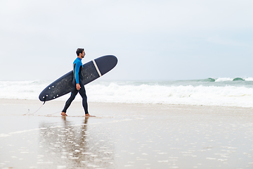 Image showing Young male surfer wearing wetsuit