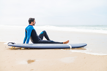 Image showing Young male surfer wearing wetsuit