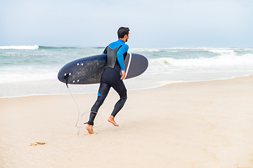 Image showing Young male surfer wearing wetsuit