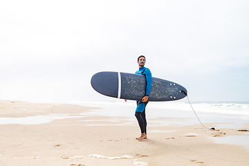 Image showing Young male surfer wearing wetsuit