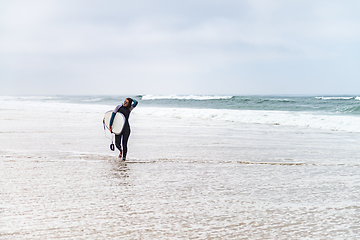 Image showing Young female surfer wearing wetsuit