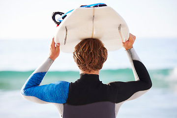 Image showing Surfing, sports and man by sea for fitness, exercise or training and walking to ocean water. Surfboard and super, person or rear of professional athlete with wellness, health and beach waves activity